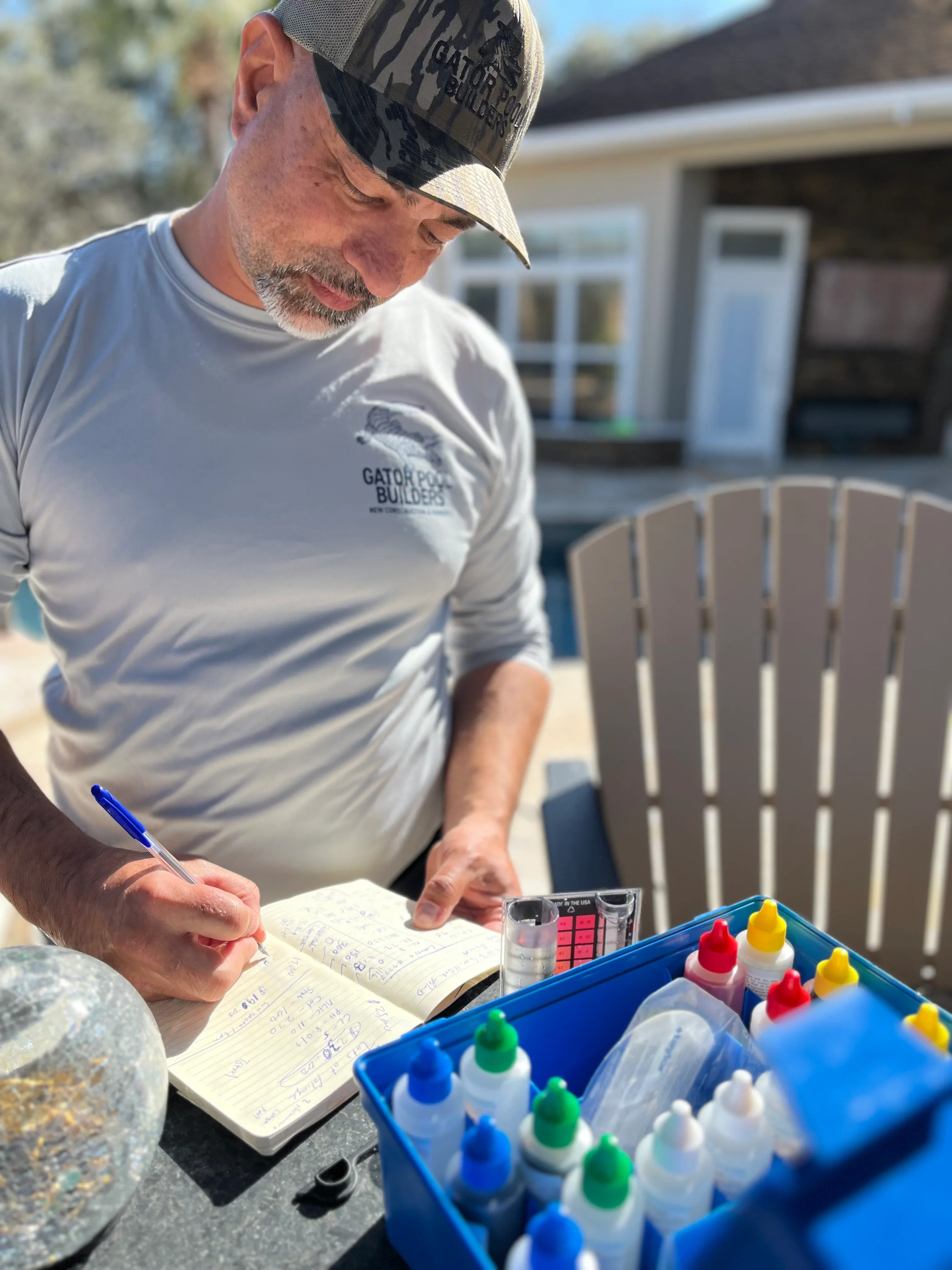 Pool builder reviewing project plans with color samples at residential property